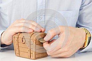 Hand putting coin into a money-box