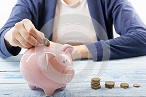 Hand putting coin into piggy bank closeup. selective focus