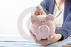 Hand putting coin into piggy bank closeup. selective focus