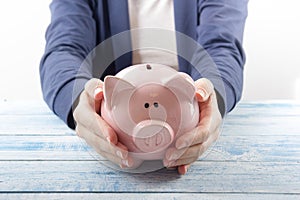 Hand putting coin into piggy bank closeup. selective focus