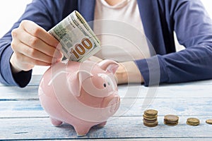 Hand putting coin into piggy bank closeup. selective focus