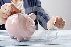 Hand putting coin into piggy bank closeup. selective focus