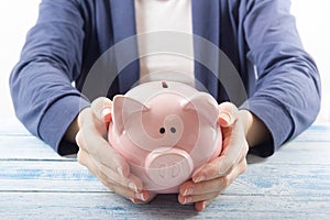 Hand putting coin into piggy bank closeup. selective focus