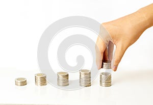 Hand putting coins to stack graph of coins on white background