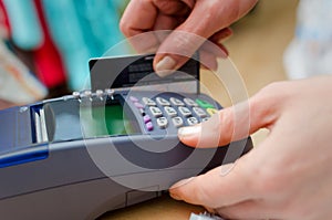 Hand putting credit card into payment machine