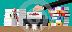 Hand putting document paper in shredder machine.