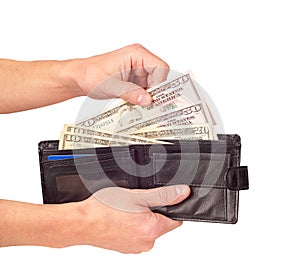Hand putting dollars in the wallet isolated on the white background
