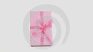 Hand putting down pink gift wrapped present and then taking it away