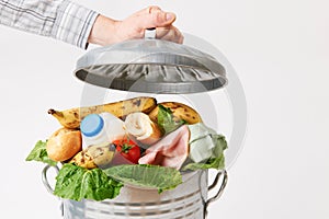 Hand Putting Lid On Garbage Can Full Of Waste Food photo