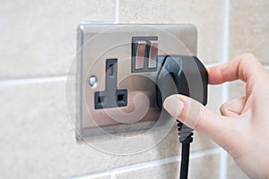 Hand Putting Plug Into Electricity Socket