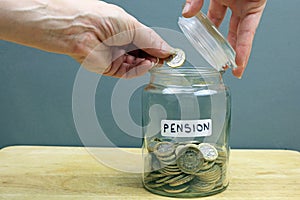 A Hand Putting A Pound Coin In To A Pension Pot