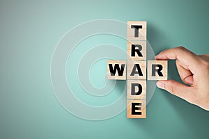 Hand putting trade war wording on green background
