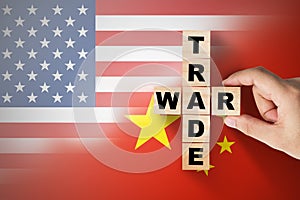 Hand putting trade war wording on USA and China flag.It is symbol of tariff trade war tax barrier between United States of America