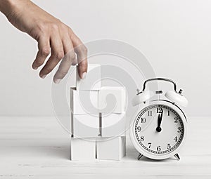 Hand putting white cubes clock. High quality and resolution beautiful photo concept