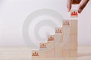 Hand putting wood cube block ladder to the top,human resource management and recruitment business concept, Business Strategy to