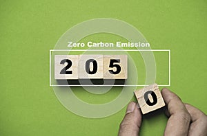 Hand putting wooden block cube of 2050 year from Kyoto Protocol for zero carbon emissions footprint and carbon credit to limit