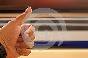 hand with raised finger giving an OK while a speeding train passes by with copy space