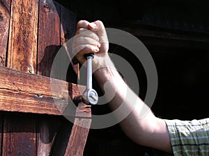 Hand with ratch on wooden door