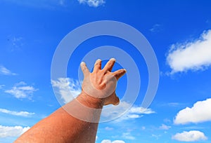 Hand reach out so it the on blue sky background