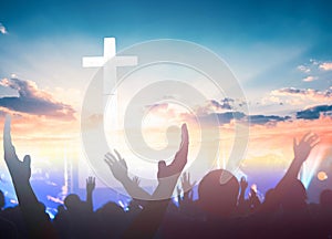 Worship and praise concept: christian people hand rising on sunset background photo