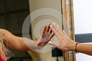 Hand reaches for her reflection