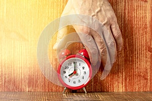 Hand reaches out to stop ringing early morning alarm clock