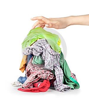 A hand reaches for a pile of clothes