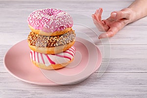 A hand reaches for three sugar-covered donuts photo