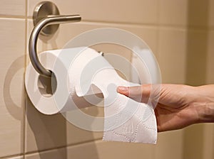 Hand reaches for toilet paper