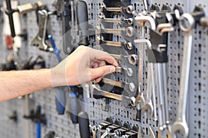 Hand reaches for tools in a bicycle repair workshop