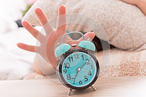 Hand reaching the alarm clock