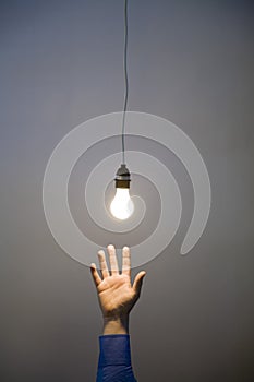Hand reaching for light bulb
