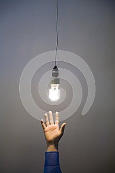 Hand reaching for light bulb