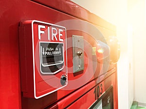 A hand reaching and pulling a red fire alarm switch. red fire alarm