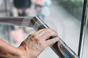 Hand reading Braille inscriptions for the blind on public amenity railing photo