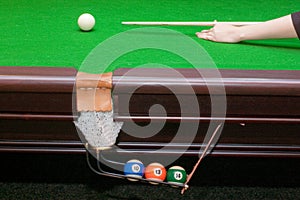 Hand ready to hit a white ball with cue