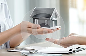 Hand a real estate agent, hold the home model, and explain the business contract, rent, buy, mortgage, loan, or home insurance to