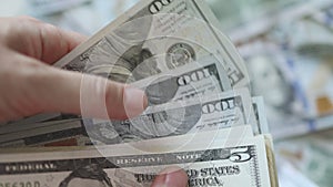 hand recounting dollar bills cash on American currency background