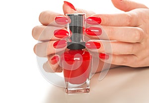 Hand with red nail polish bottle