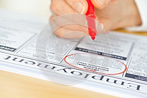 Hand with Red Pen Marking Job in Newspaper