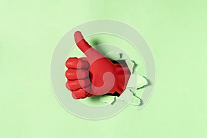 Hand in red rubber glove with thumb up gesture