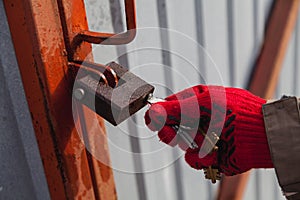 Hand opens padlock with key