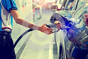 Hand refilling the car with fuel at the gas  station, car in gas station, refilling the car with fuel at the refuel station