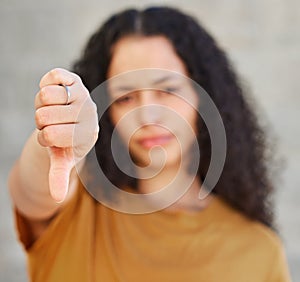 Hand, rejection and thumbs down with unhappy woman in studio on gray background for denial. Fail, feedback and review