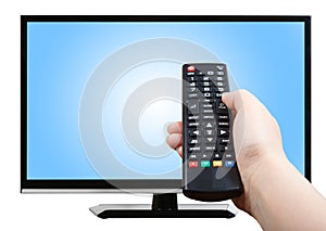 Hand with remote control pointing at modern TV set