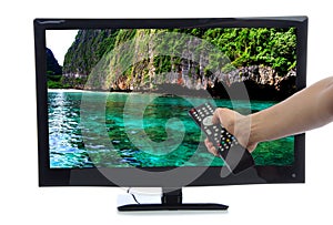 Hand with remote control turning on led tv