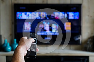 Hand with a remote control. Whats on tv, sliding through apps en movies on your television photo