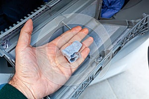 Hand removing lint from a clothes dryer filter, home maintenance photo