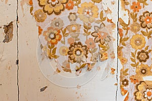 Hand removing wallpaper from wall, close-up view