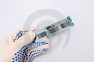 A hand of a repairer technician holding RAM, random access memory in order to upgrade an old computer against whote background,